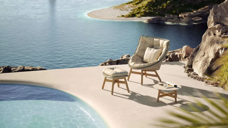 Dedon Mbrace wing chair, outdoor chairs woven in Dedon Fiber on a lakeside terrace